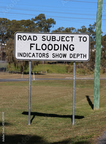 Road Subject To Flooding sign in a grassy environment