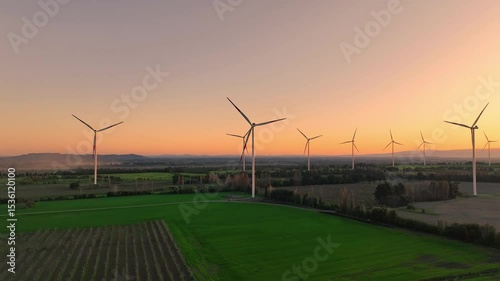 Wind turbines generate renewable energy at sunset in a vast rural landscape with vibrant colors