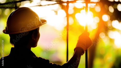 Construction Worker's Sunlit Perspective: A focused construction worker, silhouetted against a golden sun, embodies diligence and precision.