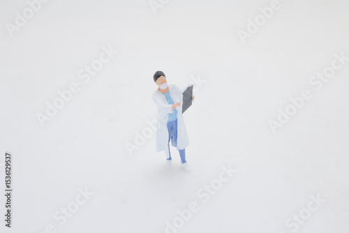 Miniature Figure of a Doctor Reading Notes in a Clinical Setting