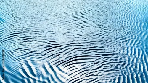 Elegant surface of water with ripples creating symmetrical patterns and abstract textures, light blue color palette, background