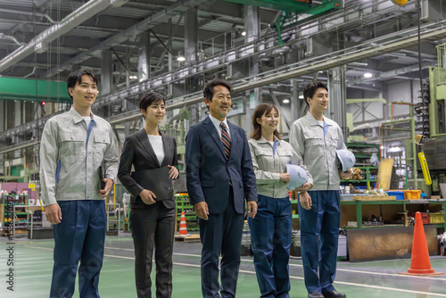  工場で並んで立つ作業スタッフのグループ