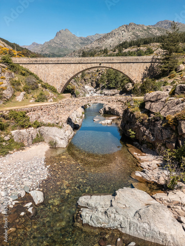 The Ponte Altu bridge sits alongside an ancient genoise bridge at Albertacce on the Mediterranean island of Corsica passing over the crystal clear Golo river