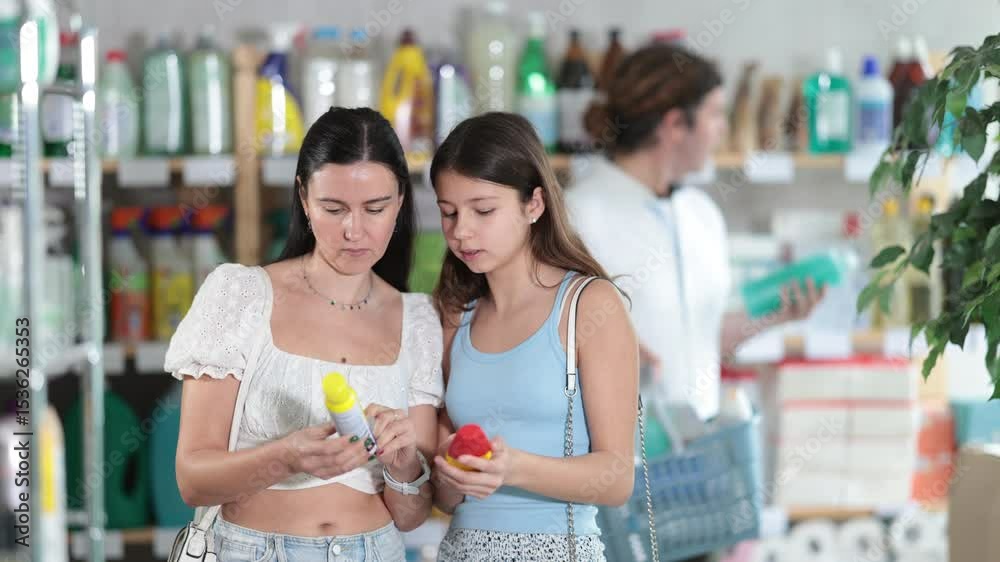 Uncertain mom and daughter in summer clothes holding repellent while man choosing something behind. High quality 4k footage