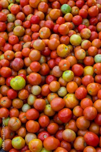 Many fresh organic tomatoes from harvest up for sale in Indian market.