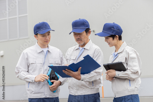 屋外でミーティングする作業員グループ