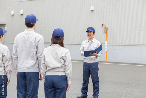 工場の前で朝礼をする作業員グループ