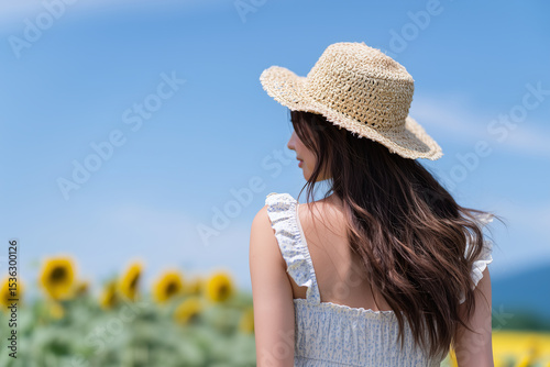 ひまわり畑に立つ女性