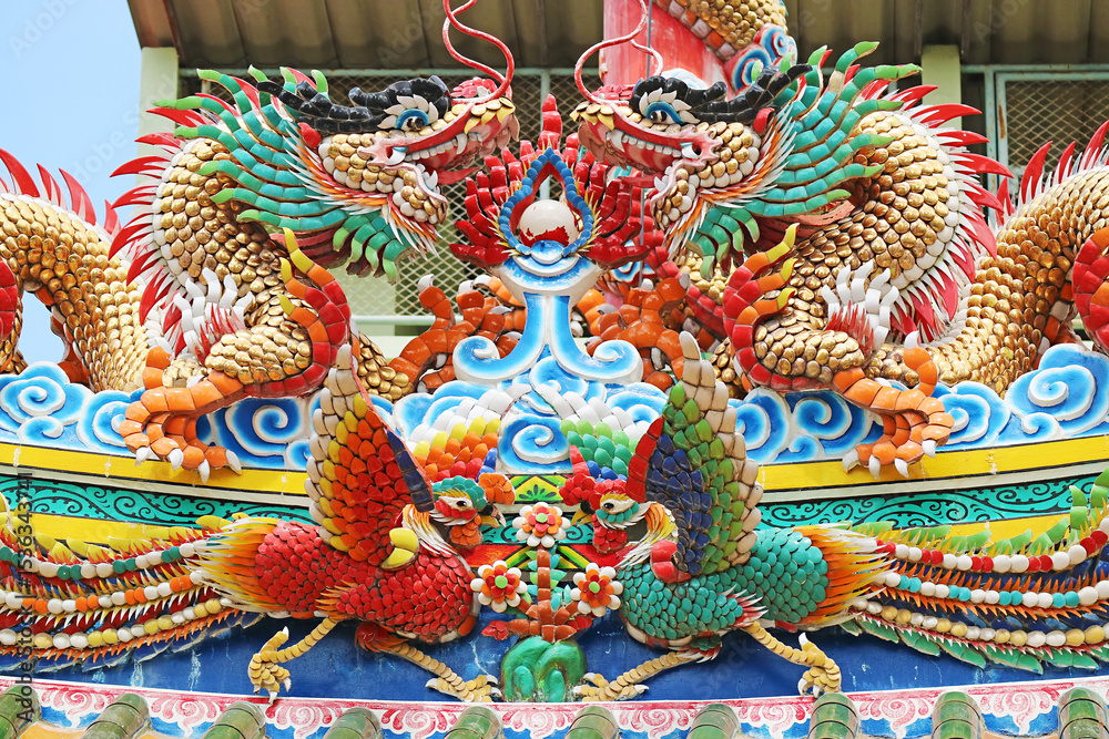 Obraz premium Two Green Dragon Chasing a Flaming Pearl with a Pair of Phoenix, Stunning Sculptures on the Roof of Lao Pun Tao Kong Taoist Shrine, Chinatown of Bangkok, Thailand