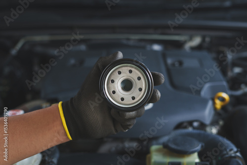 Canvas Print Mechanic holds up a new, clean oil filter, ready for installation during a routine car maintenance service