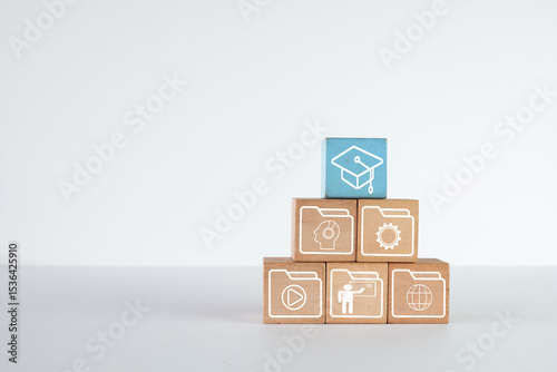 A pyramid of wooden blocks with learning skill icons and education icon on white background with copyspace.,Concept for education,skill development, online learning,personal development.