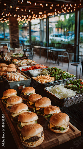 Banquet Table Displaying Burgers Fries Salads and Various Dishes in Restaurant Setting