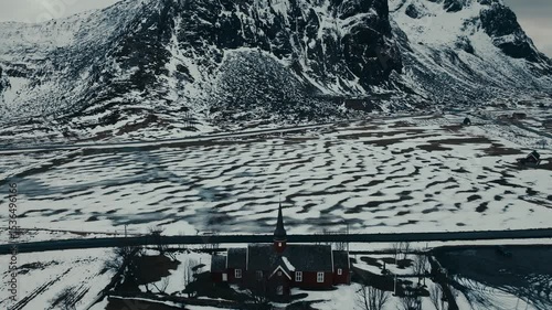Above View Of Flakstad Church In Snowscape At Ramberg In Lofoten Islands, Norway. Aerial Drone Shot