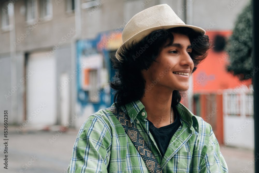 Fototapeta premium portrait of smiling young man wearing cap on the street