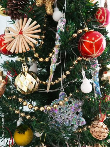 Christmas decorations, balls, snowflakes and icicles on a Christmas tree close-up.