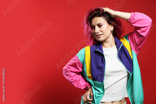 Beautiful woman with pink dyed hair on red background, space for text