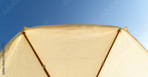 Beach umbrella against the backdrop of the blue sky by the sea