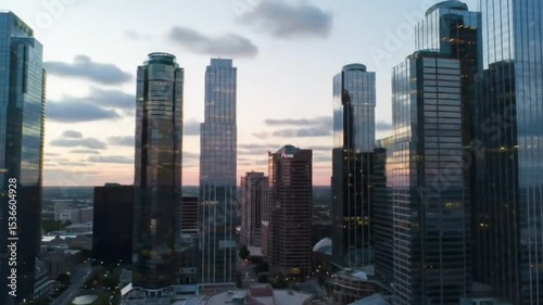 Fast-paced timelapse of city skyscrapers at golden hour, lights turning on, clouds moving fast — urban, modern business center
