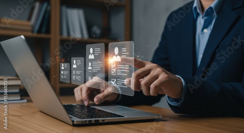 Businessman reviews candidate profiles on a laptop for recruitment and selection in a modern office setting