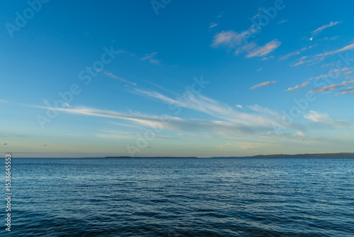 Blue sky with altostratus clouds and moon, over southern Moreton Bay, viewed from Main Beach, Coochiemudlo Island, Queensland, Australia