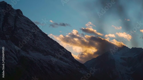 Orange clouds above snowy Himalayan mountain peaks during the sunset as seen from Keylong in Lahaul and Spiti district, Himachal Pradesh, India. Beautiful sunset in the Himalayas during winter season.