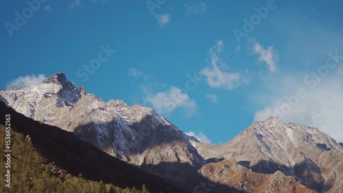 Clouds above the dried Himalayan mountain peaks during the summer season as seen from Chitkul village in Kinnaur district, Himachal Pradesh, India. Scenic view of Himalayas in summer season.