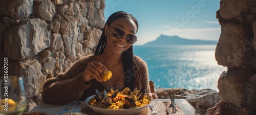 The woman enjoying a delicious seafood meal by the ocean in a scenic setting.