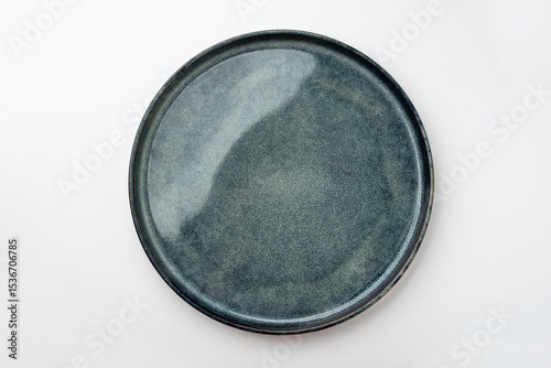 An empty textured plate on a white table