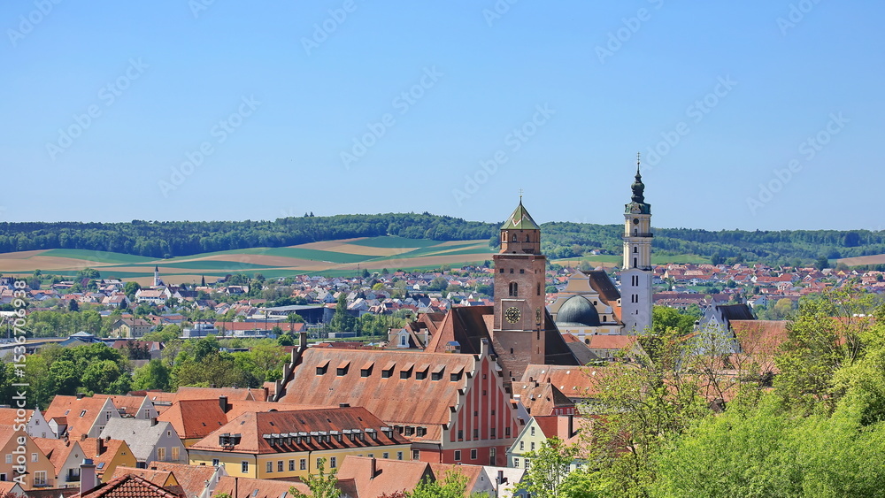 Obraz premium Luftaufnahme von Donauwörth mit roten Dächern, historischen Gebäuden und einem markanten Turm, eingebettet in eine grüne Landschaft. Die Stadt bietet eine charmante Kulisse.