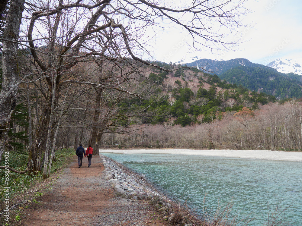 Obraz premium 初夏の観光名所上高地の穂高連峰と梓川の風景と散歩する観光客の姿