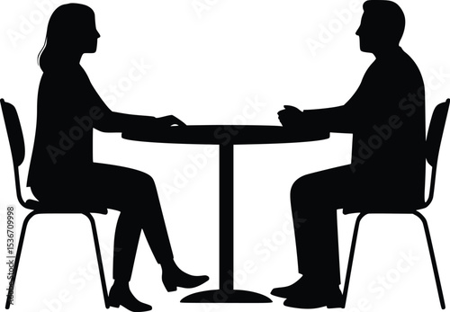 Silhouette of two people seated at a round table in a business conversation or meeting

