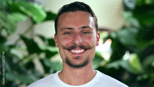 Portrait of Happy Man Looking at Camera and Smiling on Green Plant Background. Headshot of Young Face of One Cute French Person Indoor at City Park. Close Up Shot of Attractive Male at Summer Vacation