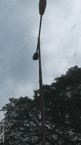 Observing Tall Street Light against a Cloudy Sky Background