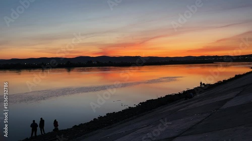 sunset over the river. people on the riverbank embankment