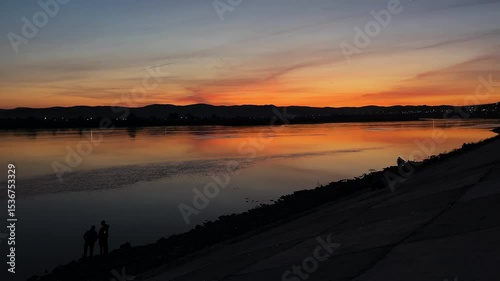sunset over the river. people on the riverbank embankment