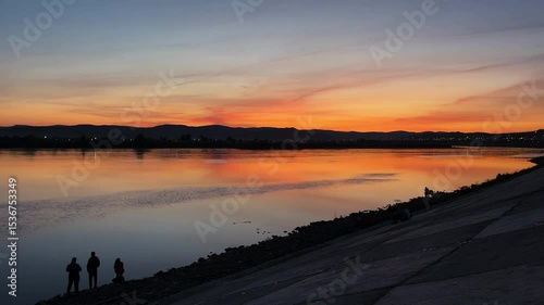 sunset over the river. people on the riverbank embankment