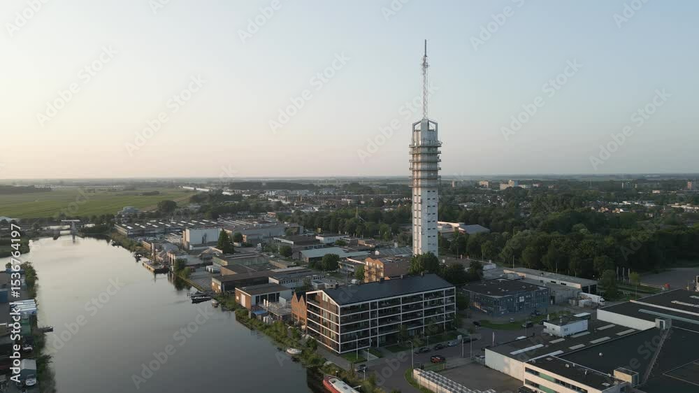 Aerial view of Rijnhaven marina in Alphen aan den Rijn with a tall communication tower beside the water, captured during golden hour.