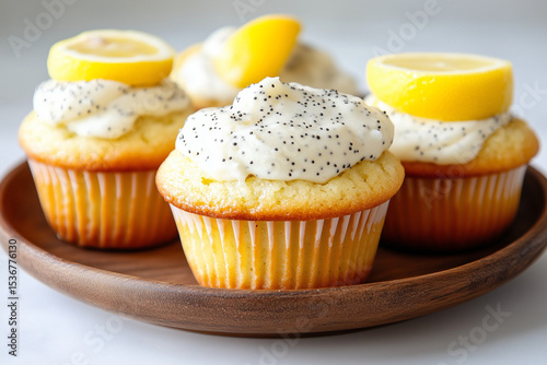 Freshly baked lemon poppy seed cupcakes are showcased on a wooden plate, featuring smooth frosting and vibrant lemon slices for a delightful treat