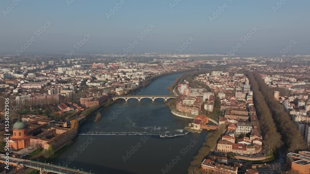 Aerial view of Garonne river crossing Toulouse in France, featuring the dome of Hopital de La Grave and Pont Neuf bridge