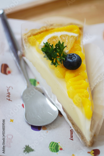 Close up shot of mango fruit cake decorate with orange and blueberry
