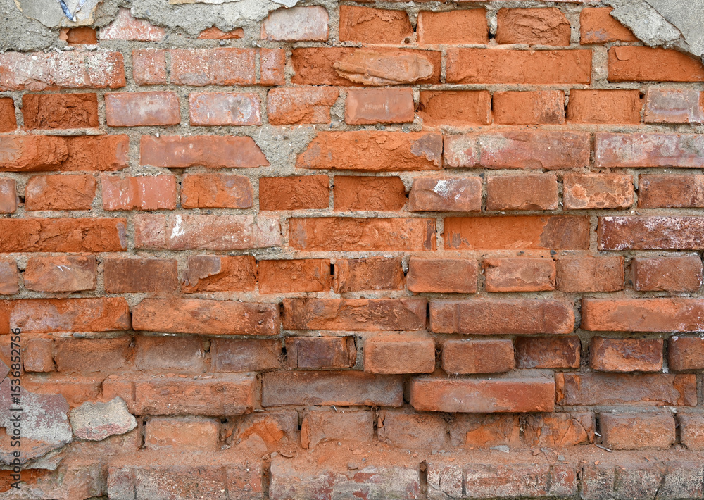 Fototapeta premium Textured brick wall showcasing various shades of red and orange with visible mortar joints in natural light