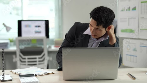 Office syndrome concept, businessman having neck pain and shoulder pain from working in front of laptop for a long time, massaging his neck and shoulders to relieve pain