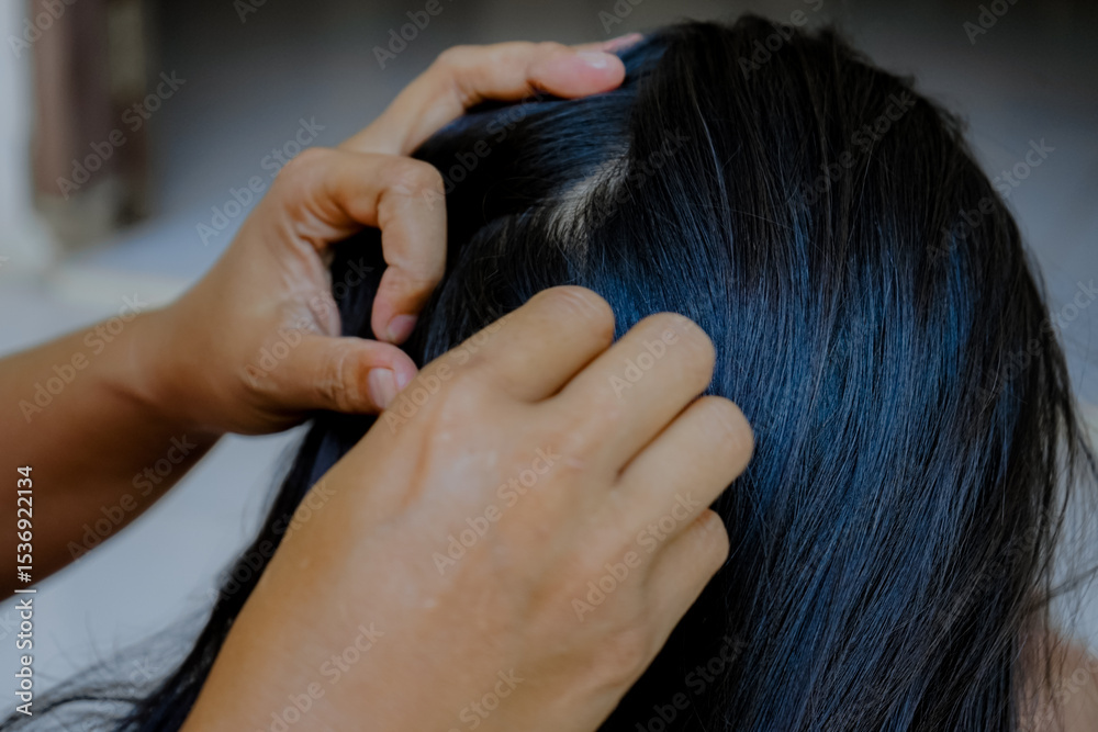 Fototapeta premium closeup of hands looking for lice in hair