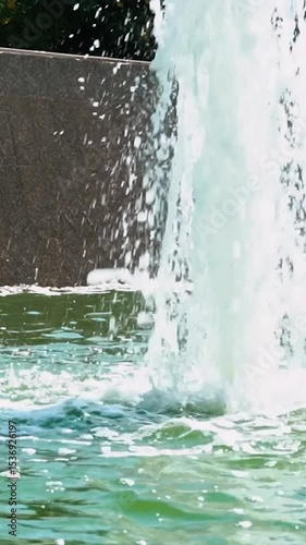 refreshing water fountain in the park in summer during hot weather and scorching sun. Bright blue and turquoise water with bubbling splashes quenches thirst