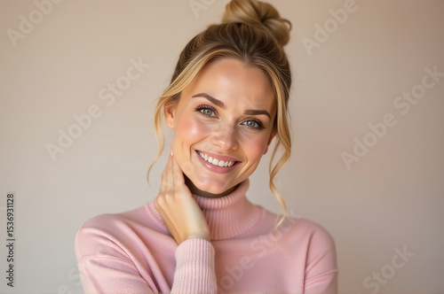 A happy woman wearing a pink turtle neck sweater smiles for the camera