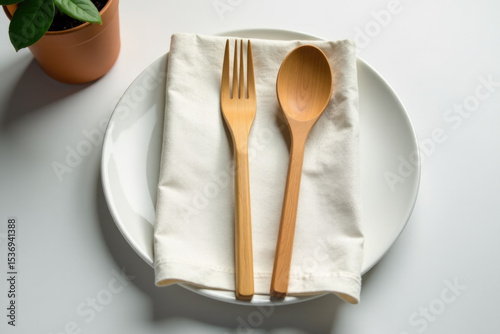 A simple setup of wooden spoon and fork on a white plate, ideal for still life photography or cooking scenes