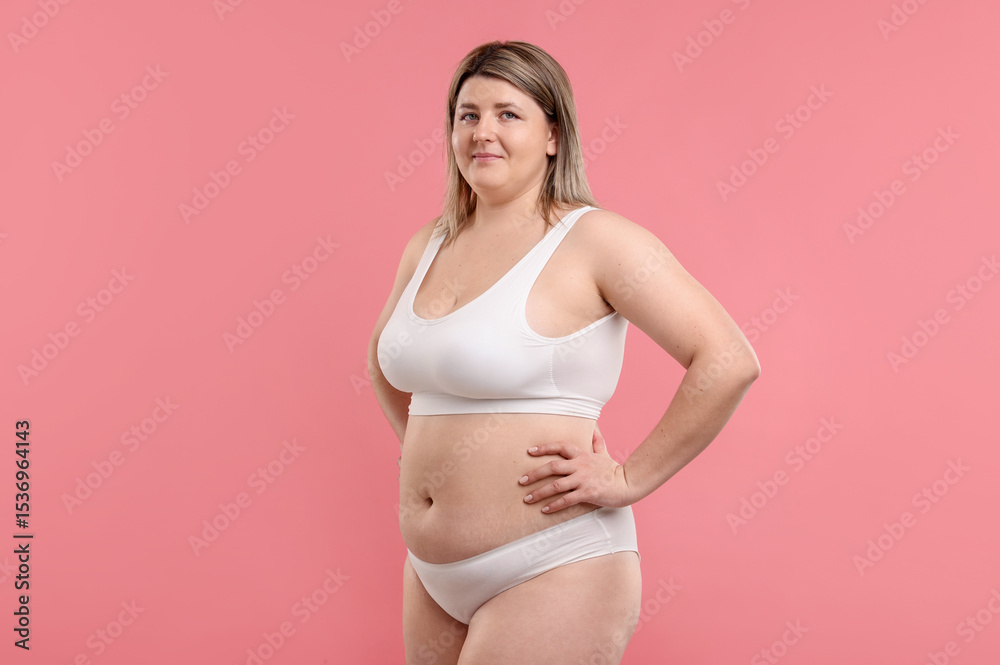 Fototapeta premium Weight loss. Plus size woman in underwear on pink background