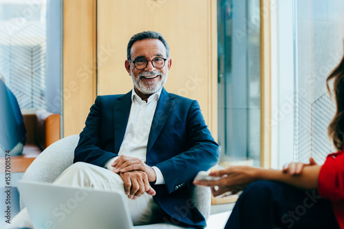 Senior businessman smiling during a meeting in a modern office setting