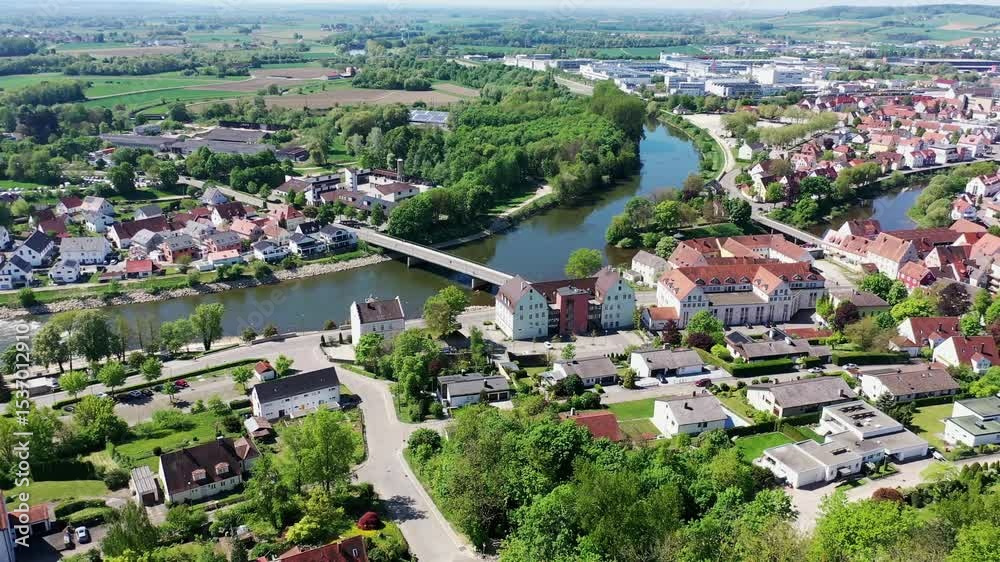 Luftaufnahme von Donauwörth mit roten Dächern, historischen Gebäuden und einem markanten Turm, eingebettet in eine grüne Landschaft. Die Stadt bietet eine charmante Kulisse. Donauwörth, Schwaben,