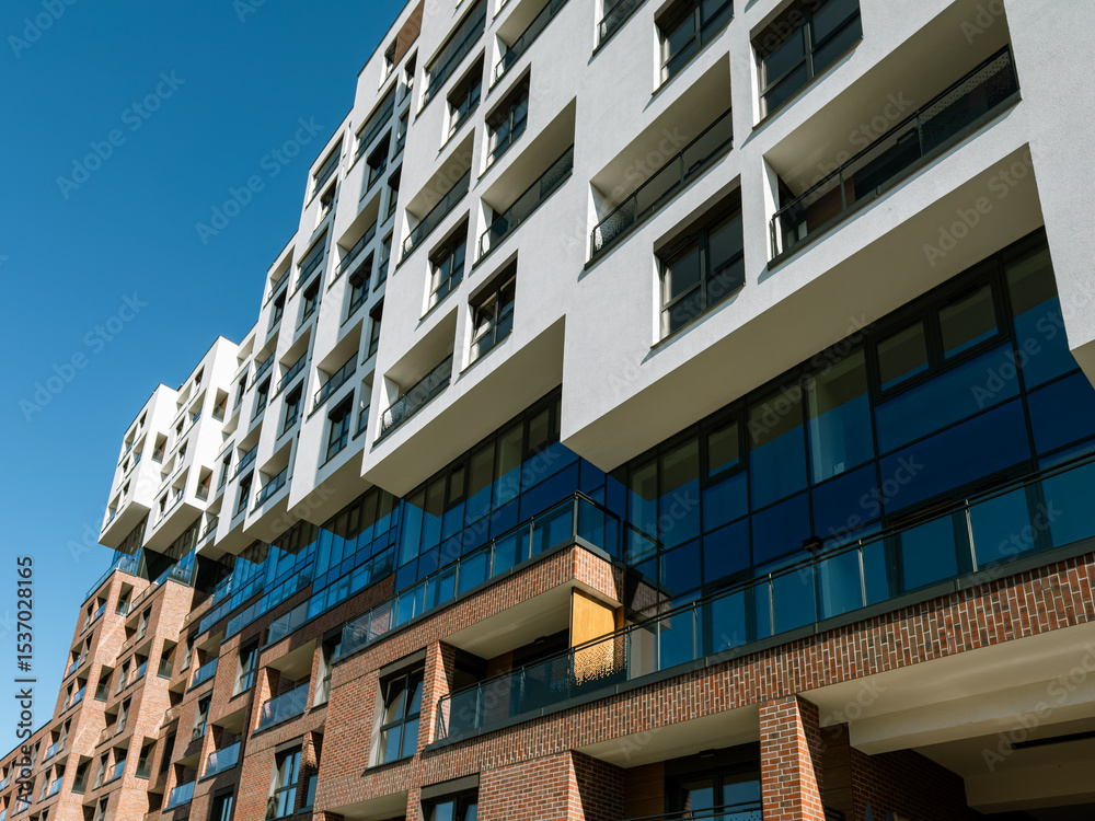 Obraz premium Contemporary residential architecture in South Spain featuring geometric balconies, large windows, and a mix of brick and glass, ideal for real estate and urban living concepts.